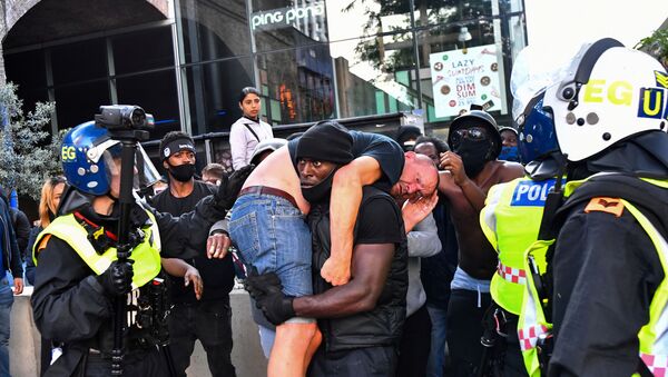 İngiltere’nin başkenti Londra’daki ırkçılık karşıtı protestolarda Patrick Hutchinson adlı siyah, yaralı beyaz bir adamı sırtına alarak güvenli bir yere taşıdı. - Sputnik Türkiye